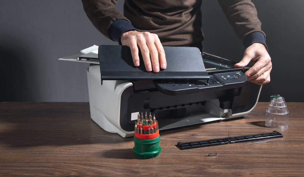 man repairing digital printer